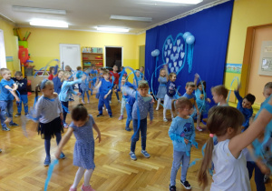 Dzieci kręcą kółka paskami niebieskiej bibuły